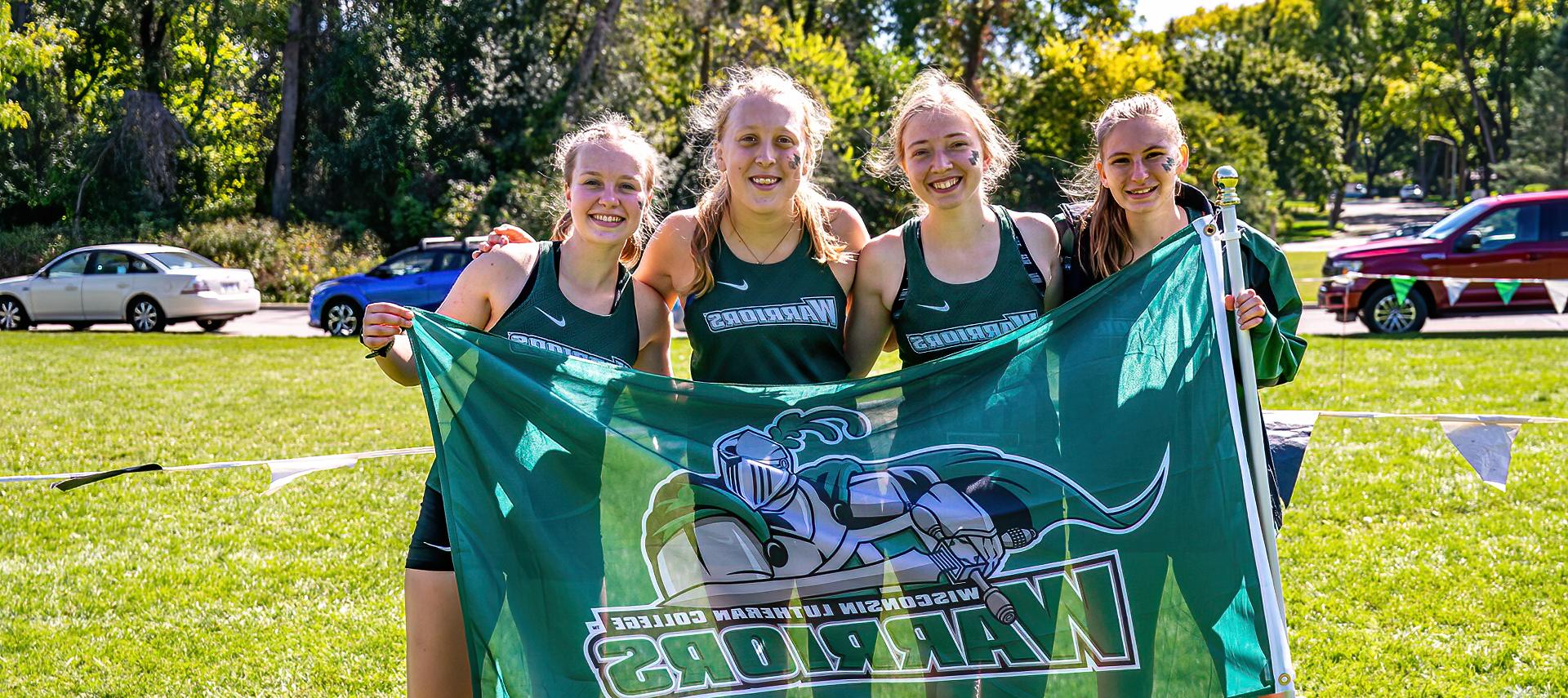 Cross-country student-athletes holding a Warriors flag